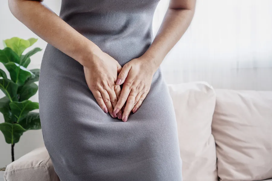 Woman places hands over lower abdomen